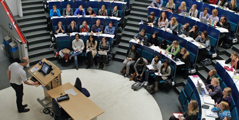 Studenten in zaal die luisteren naar een professor